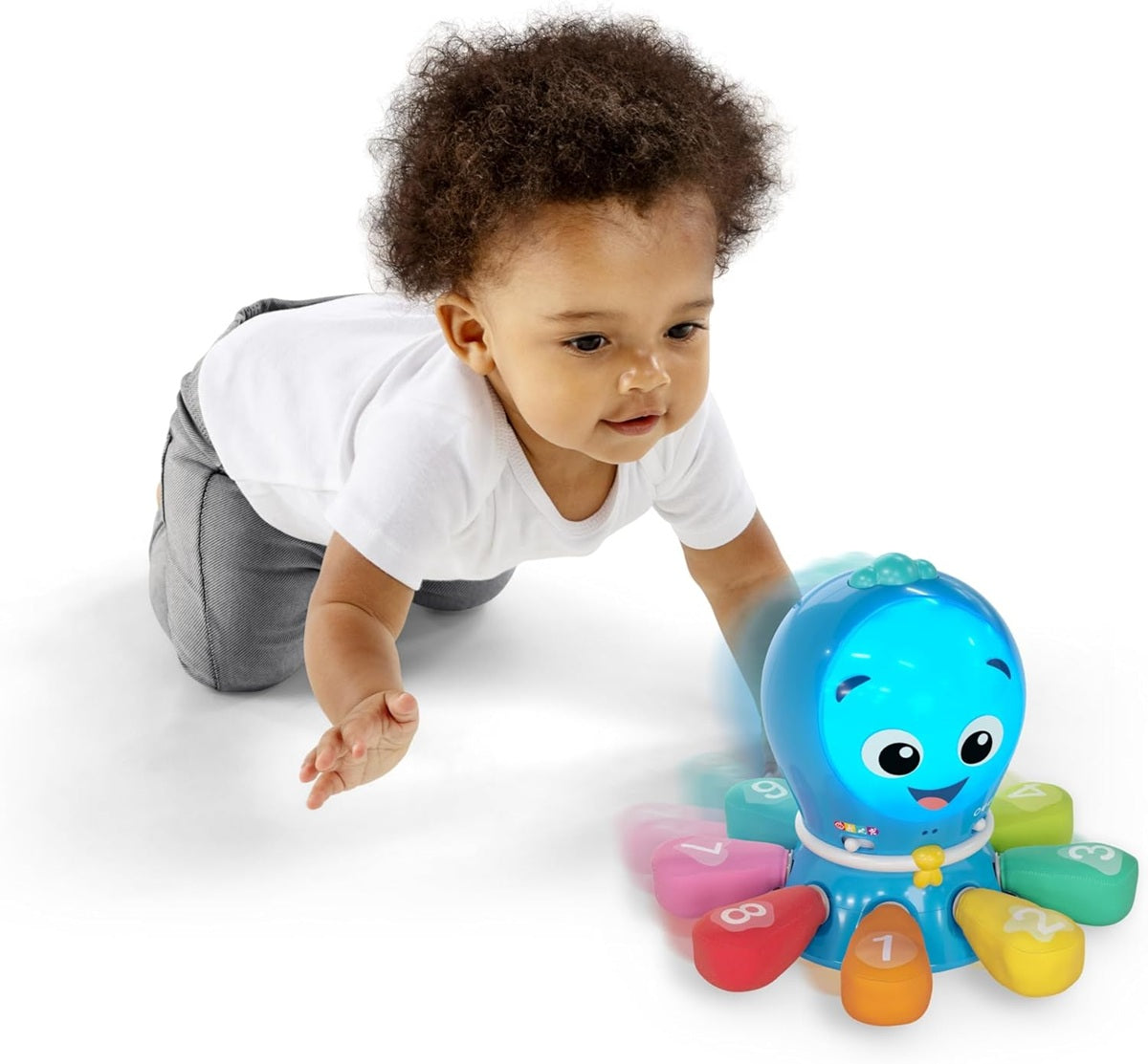 Raczkujące dziecko w jasnoszarym ubraniu sięgające do ośmiornicy Baby Einstein Ocean Explorers.