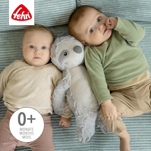 Dwoje dzieci leżących na macie z szarym leniwcem FEHN XL między nimi.