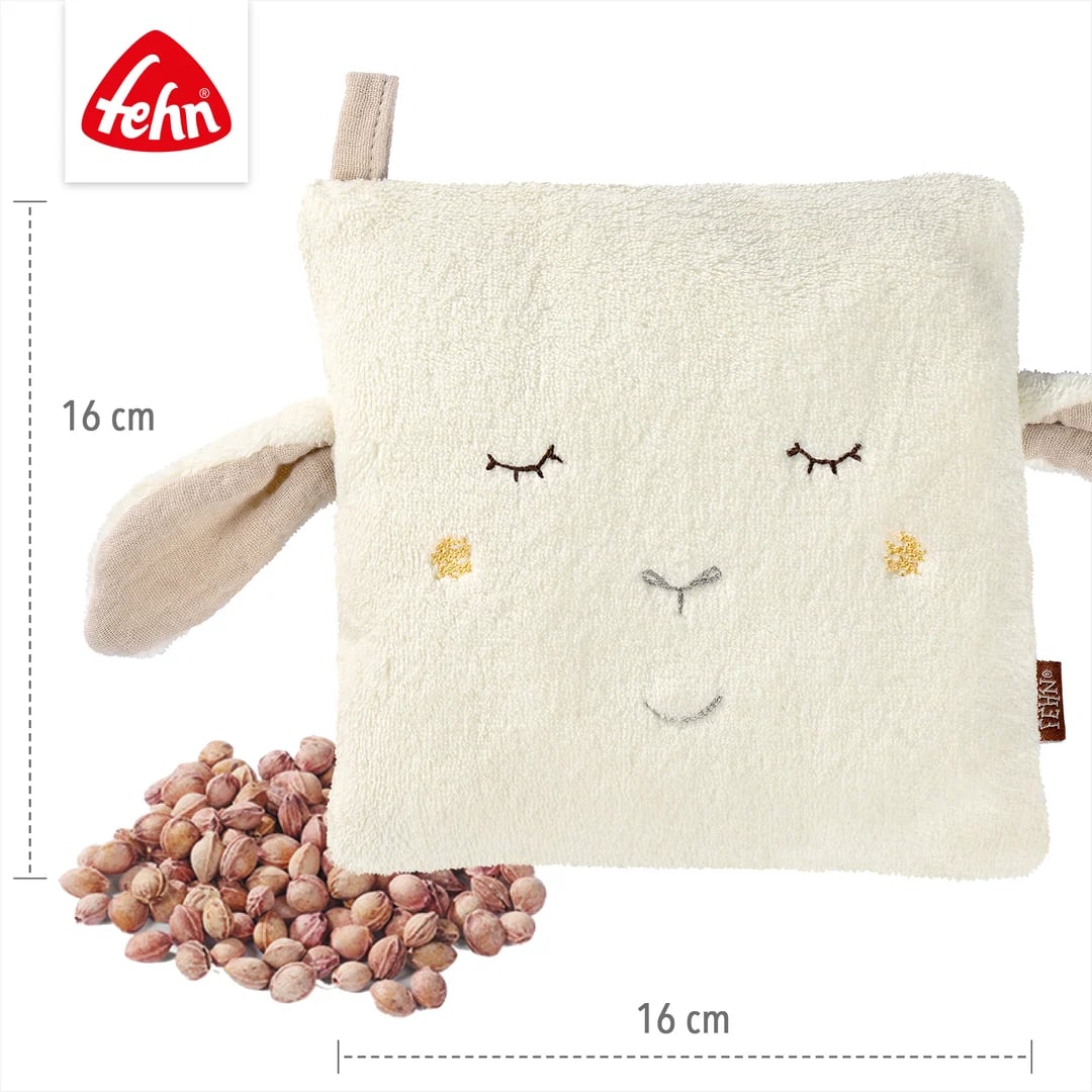 Grafika poglądowa poduszki owieczki obok rozsypanych pestek i linii wymiarowych.