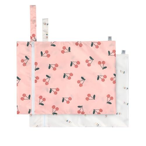 Dwie torby LÄSSIG Happy Fruits Cherry: różowa we wzór wiśni i jasna z kolorowymi napisami, z zamkami i pętelkami.